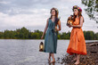 © Danil - Two young and lovely girls in flower wreaths in nature. Ancient pagan origin celebration concept. Summer solstice day. Mid summer. Ancient rituals.