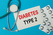 © Superzoom - Card with text DIABETES TYPE 2, pills and stethoscope.