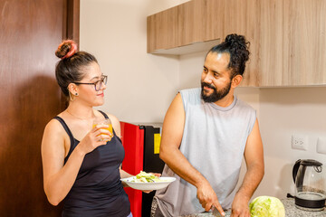 Pareja de mexicanos preparando ensalda en casa vida saludable