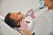 Esthetician in sterile gloves performing laser hair removal procedure