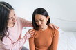 © Ann Patchanan - Friendship and people consoling friend concept.Good friends embracing in a bedroom.Two women talking about problems at home unhappy girl support and care her friend.