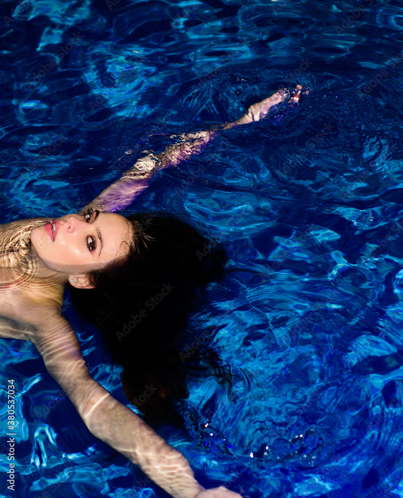 Beautiful girl swimming in pool. Hot party. Sexy slamorous lady