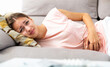 © JackF - Portrait of depressed girl lying on sofa with stomach problems