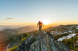© Isaac Lane Koval/Stocksy - Man on top of mountain at sunset