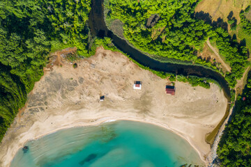 Aerial top view of a wild sandy beach, surrounded by river, sea waters and green forest on the southern Black Sea coast, Bulgaria