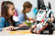 © LIGHTFIELD STUDIOS - Selective focus of robot near pupils using computer in stem school