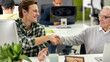 © Svitlana - Aged man, senior intern smiling at his young colleague, shaking hands, Friendly male worker cheering new employee while working in the office