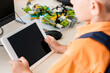 © LIGHTFIELD STUDIOS - Cropped view of schoolboy holding digital tablet in stem school