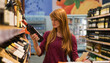 © Mosuno/Stocksy - Ginger Woman Buying Wine in a Supermarket