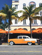 © Jared Harrell/Stocksy - Classic Car outside Art Deco Hotel in South Beach, Miami