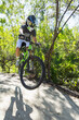 © Adam Nixon/Stocksy - Female mountain biker catching air