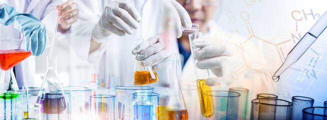 hand of scientist holding flask and pouring sample to test tube in chemical laboratory background, science laboratory research and development concept