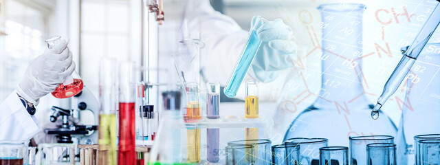 Wall Mural - hand of scientist holding flask and pouring sample to test tube in chemical laboratory background, s