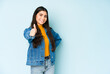 © Asier - Young indian woman isolated on blue background smiling and raising thumb up