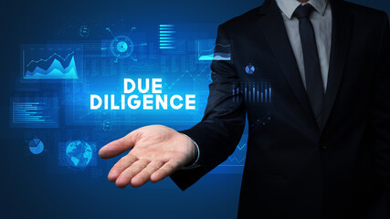 Hand of Businessman holding DUE DILIGENCE inscription, business success concept