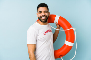 Young latin lifeguard man isolated looks aside smiling, cheerful and pleasant.