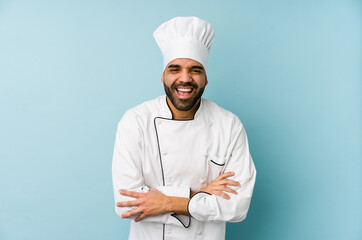 Wall Mural - Young latin chef man isolated laughing and having fun.