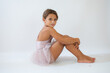© Danko - Beautiful little ballerina on floor doing stretching over white background