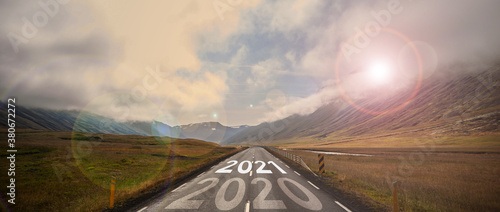 Cuadros en Lienzo The word 2021 written on highway road in the middle of empty asphalt road at golden sunset and beautiful blue sky