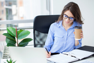 Wall Mural - Portrait of beautiful young woman working in the office.