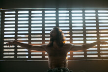 Man Posing Like Crucified Jesus In Backlight