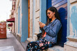 © Kike Arnaiz/Stocksy - Beautiful hispanic woman scrolling on her phone