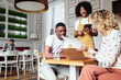 © Bonninstudio/Stocksy - Cheerful waitress taking order from diverse couple