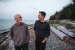 © Rob and Julia Campbell/Stocksy - Father and grown son talking together on the beach.