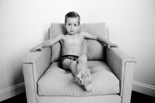 Cute Young Boy In Just Underwear Sitting In A Chair