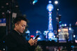 © MaaHoo Studio/Stocksy - Portrait of man using cellphone by street in city of Shanghai