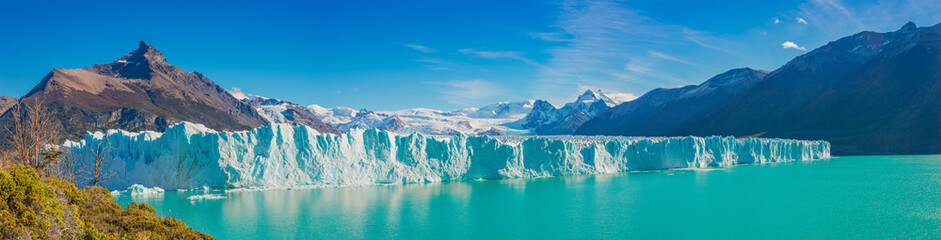  Panoramic view over gigantic Perito Moreno glacier in Patagonia with blue sky and turquoise water glacial lagoon, South America, Argentina, at sunny day..
