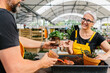 © MyMicrostock/Stocksy - Mid adult couple working in a greenhouse