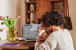 © Guille Faingold/Stocksy - Woman working on laptop and drinking coffee.