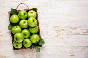 Ripe green apples in wooden box.