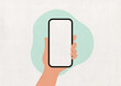 Hand holding a phone with blank screen on a mint paper background