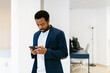 © MyMicrostock/Stocksy - Contemporary black businessman with phone in office