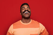 © MyMicrostock/Stocksy - Happy african american man over red background
