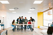 © MyMicrostock/Stocksy - Stylish and creative colleagues at desk in office