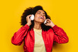 © MyMicrostock/Stocksy - Beautiful afro woman listening to music with white headphones