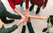 © MyMicrostock/Stocksy - Crop people stacking hands in unity spirit