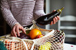 © sally anscombe/Stocksy - Fruit and vegetables on a string shopping bag