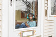 © Gabriel (Gabi) Bucataru/Stocksy - Sad black girl on her front door with headphones