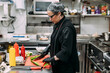 © Pixel Stories/Stocksy - Female chef cooking in industrial kitchen