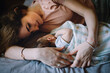 © Tanya Yatsenko/Stocksy - Mother with a newborn daughter on a bed