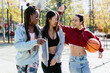 © JImena Roquero/Stocksy - Multi ethnic group of friends with basketball ball hanging out