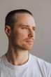 © Ivan Ozerov/Stocksy - young attractive short-haired man in a white t-shirt looks away