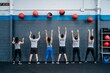 © Sergio Marcos/Stocksy - Anonymous multiehtnic group exercising with wall ball throws in a crossfit training