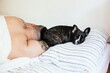 © vradiy.ru/Stocksy - Owner and Pug dog resting in bed together