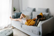 © JImena Roquero/Stocksy - Young woman reading on the sofa