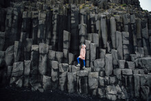 Woman Standing On Basalt Rock Formations